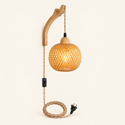 Bamboe wandlamp met gevlochten bolkap aan een gebogen houten arm, lamp aan